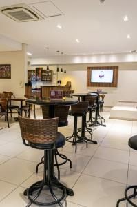a dining room with tables and chairs and a tv at Hotel Malibu Inn Campinas in Campinas +35 photos