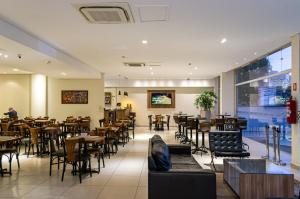 ein Speisesaal mit Tischen und Stühlen und ein Restaurant in der Unterkunft Hotel Malibu Inn Campinas in Campinas