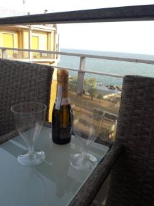 萨莱诺V I P Suites Cielo Stellato on Concordia Sea的桌子上一瓶葡萄酒和两杯