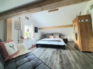 ein Schlafzimmer mit einem Bett und einer Couch in der Unterkunft Hüttenglück in Innernzell