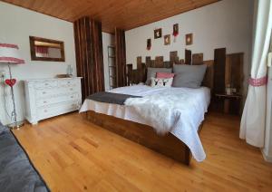 a bedroom with a large bed with a wooden headboard at Hüttenglück in Innernzell
