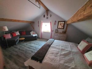ein Schlafzimmer mit großem Bett und Couch in der Unterkunft Hüttenglück in Innernzell