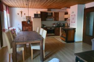 eine Küche mit Holztisch und ein Esszimmer in der Unterkunft Hüttenglück in Innernzell + 20 Fotos