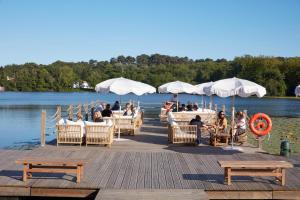 a group of people sitting on a dock on the water at Brindos, Lac & Château - Relais & Châteaux - Anglet Biarritz in Anglet