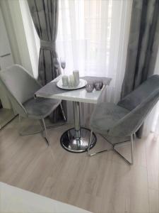 a table and two chairs and a table and a window at City Lux Apartments in Skopje