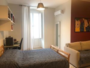 um quarto com uma cama, um sofá e uma janela em Borghetto Pedale in Town em Terlizzi