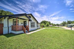 una piccola casa bianca con un ampio cortile di Airy Central Getaway with Porch and Private Yard! a Tulsa