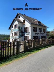 ein weißes Haus mit einem Zaun davor in der Unterkunft Resort Mezná in Hřensko