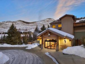 a house with snowy mountains in the background at Aspen at Streamside at Vail in Vail