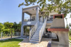 a house with stairs leading up to the front of it at SK Suites Thassos in Skala Potamias