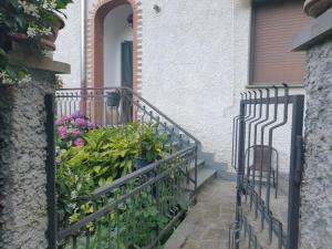 Ein schwarzer Zaun vor einem Haus mit Blumen in der Unterkunft CasaMarvi in Mezzanego + 3 Fotos