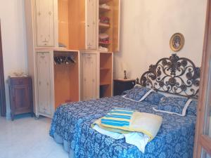 ein Schlafzimmer mit einem Bett mit blauer Tagesdecke in der Unterkunft CasaMarvi in Mezzanego