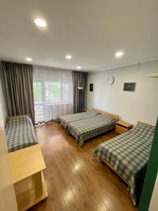 a hotel room with two beds and a window at Hotel Crocus in Bosteri