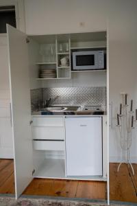 a kitchen with white cabinets and a microwave at Ferienwohnung Sandwirtin in Schwanberg