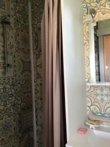 a bathroom with a shower curtain next to a sink at Tiny House aux Chevaux du Perche 