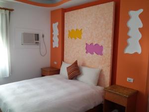 a bedroom with a bed and a wall with stickers at Country Kos Hostel in Kenting