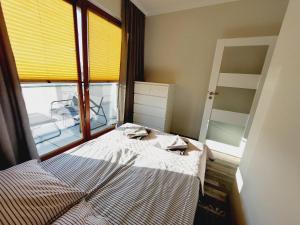 een kleine slaapkamer met een bed en een raam bij Apartament Słoneczna z parkingiem in Świnoujście
