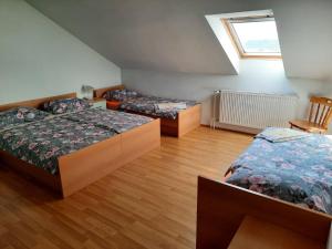 a bedroom with three beds and a window at Tourist Farm Lavrič in Woditz