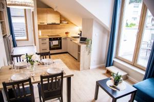 a kitchen and dining room with a table and chairs at Apartamenty z tarasami - Moja Gdynia in Gdynia
