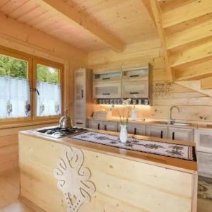 una cocina con una isla central en una cabaña de madera en Gościniec Dziubasowki en Nowy Targ