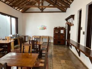 a restaurant with wooden tables and chairs in a room at Pousada Minas Goiás in Tiradentes