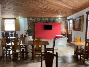 ein Esszimmer mit einem Tisch und einer roten Wand in der Unterkunft Pousada Minas Goiás in Tiradentes