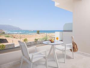 a dining room with a table and chairs and a view of the beach at Pyrgos Blue in Malia