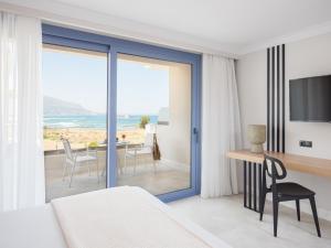 a bedroom with a bed and a view of the ocean at Pyrgos Blue in Malia