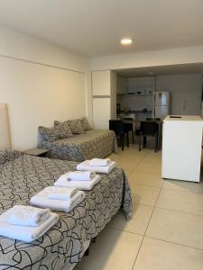 a living room with two beds and a kitchen at SMA FLATS in Neuquén