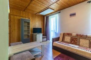 a living room with a couch and a television at Ośrodek Wypoczynkowy AS PIK dawniej Hotel AS PIK in Niechorze