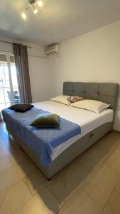 ein Schlafzimmer mit einem großen Bett mit einer blauen Decke in der Unterkunft Apartmani Slavonija in Orebić