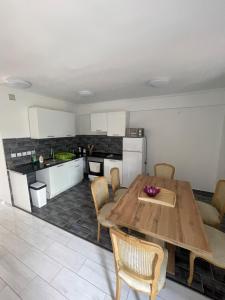 a kitchen with a wooden table and chairs at Corner House Zsóry Spa in Mezőkövesd