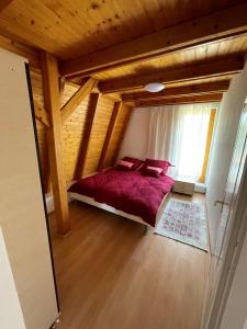 een slaapkamer met een bed in een kamer met houten plafonds bij Corner House Zsóry Spa in Mezőkövesd