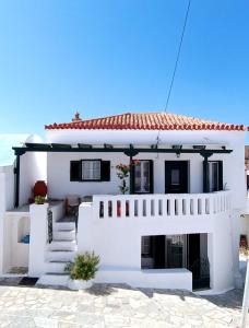 a white house with a white wall and stairs at Cycladic Maisonette (Dryopida, Kythnos) in Kithnos