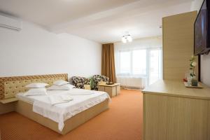 a hotel room with a bed and a television at SaloS Beach Resort in Mamaia Sat/Năvodari