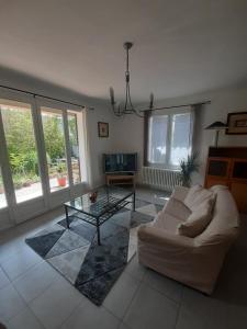 sala de estar con sofá blanco y mesa de cristal en Villa " Les Bambous " , Jardin , Terrasse , Climatisation , Wifi , Parking en Aviñón