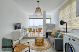 ein Wohnzimmer mit Sofa und Tisch in der Unterkunft Stylish Sea View Accommodation Las Canteras in Guanarteme