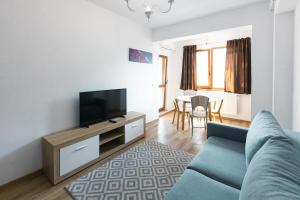 sala de estar con sofá y TV de pantalla plana en Rivera Apartments - Premium Accomodation en Iaşi