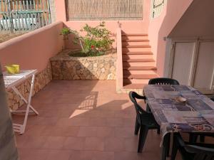 un patio con mesa, sillas y escaleras en Lopadusa trilo 2 en Lampedusa