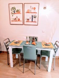 モンテ・ゴルドにあるApartamento Playa de Monte Gordoのダイニングルームテーブル(椅子2脚、食べ物を入れたテーブル付)