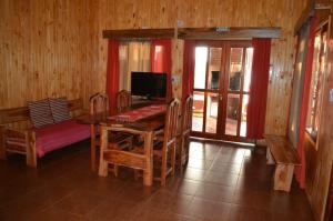 - une salle à manger avec une table et des chaises en bois dans l'établissement Cabañas Raíces Pampeanas, à Puerto Iguazú