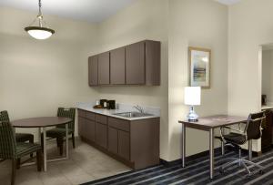 a kitchen with a sink and a table and chairs at Sky Point Hotel & Suites - Atlanta Airport in Atlanta