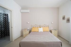 sypialnia z łóżkiem i 2 szafkami nocnymi w obiekcie Villa Machri - Con Piscina Privata E Ampio Giardino Vicina Al Mare w mieście Gagliano del Capo