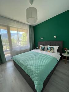 - une chambre verte avec un grand lit et un mur vert dans l'établissement Cite Jardin Apart @ 2 Bedroom Apartment, à Sofia