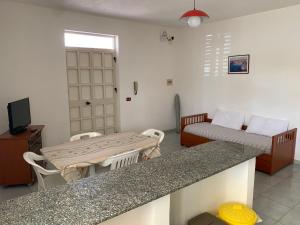 sala de estar con mesa, cama y barra en Lopadusa trilo 2 en Lampedusa
