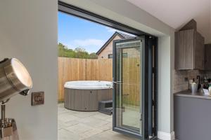 a kitchen with a sliding glass door to a tub at Fig Tree Cottage in Tenby