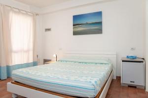 a bedroom with a large bed with a picture on the wall at La casetta di Lu Casteddu in San Teodoro +7 photos