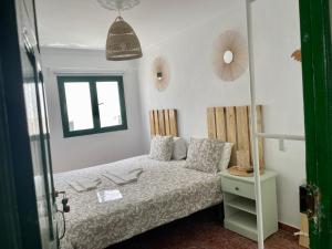 a small bedroom with a bed and a window at Pensión Playa in Puerto de Mogán