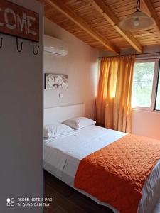 Schlafzimmer mit einem Bett und einem Fenster in der Unterkunft Takis & Eirini Family Apartments in Perama