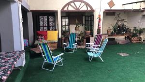 grupa krzeseł siedzących na zielonej podłodze w obiekcie Americo Hostel w mieście São Luís